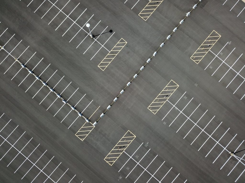 Top-down view of a large, empty parking lot featuring clear lines and patterns.