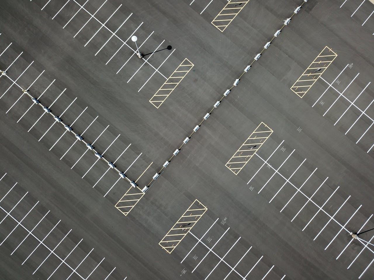 Top-down view of a large, empty parking lot featuring clear lines and patterns.